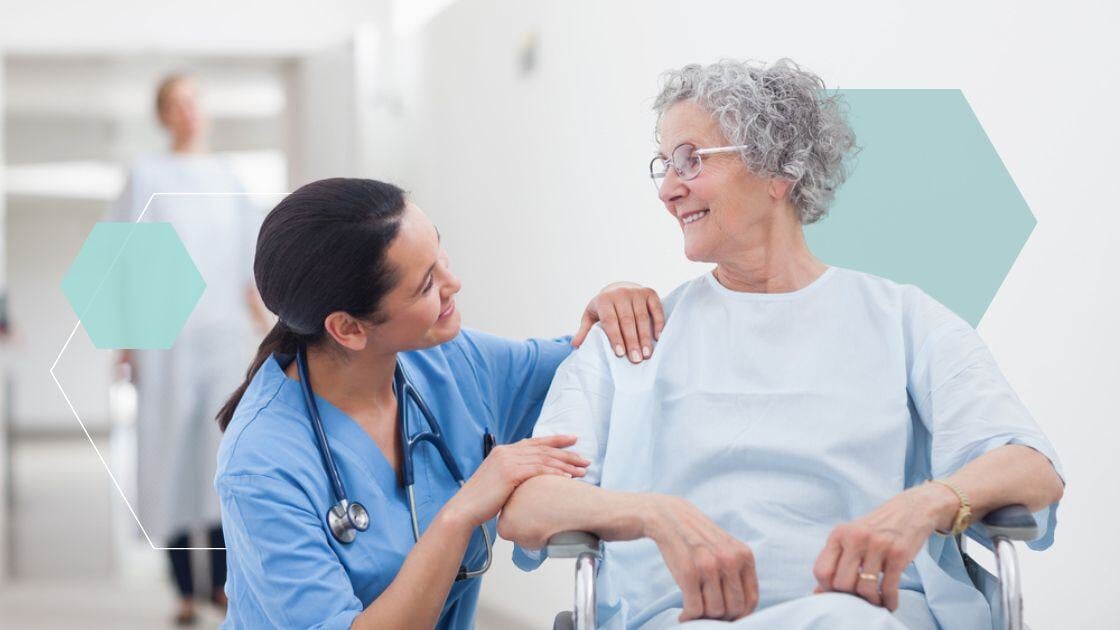 Elderly patient looking at a nurse in hospital ward