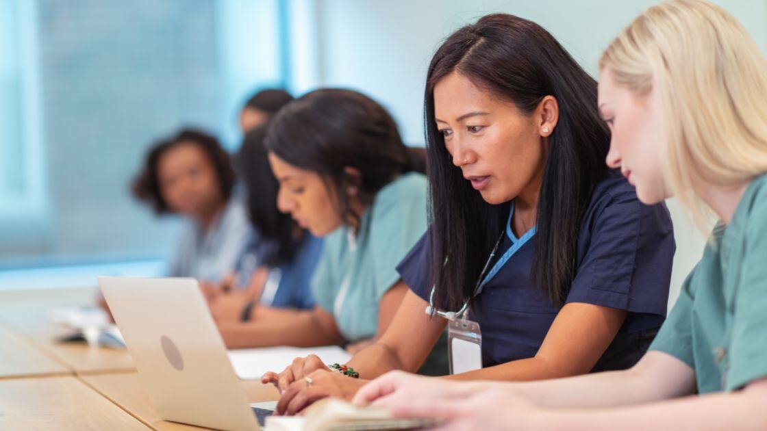 Nurses reviewing a report on the computer