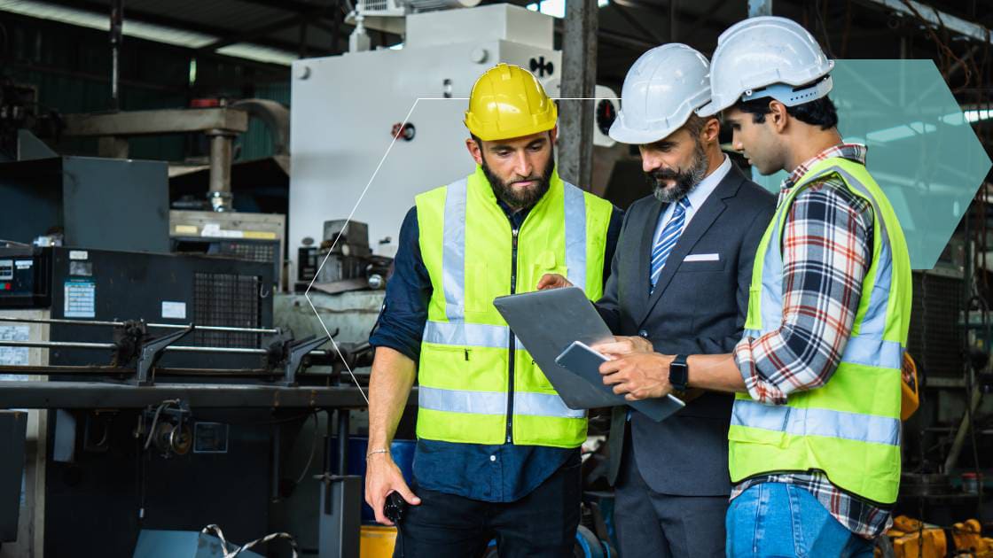 Three facility workers going over plans on a tablet